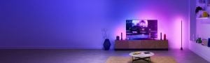 A living room with immersive light coming from multiple smart lights, all synced to the colors of the TV screen.